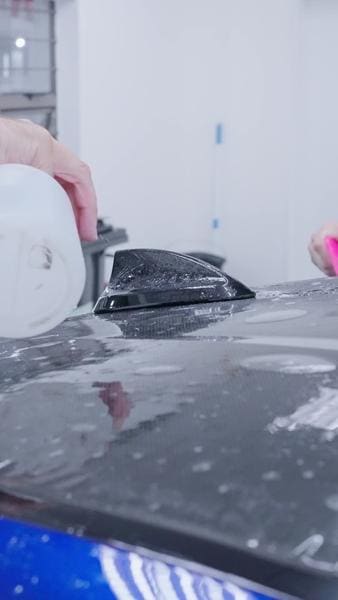 XPEL paint protection film being applied over a vehicle paint panel