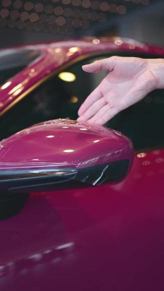 Paint protection film on a premium vehicle mirror with road debris shown on the surface