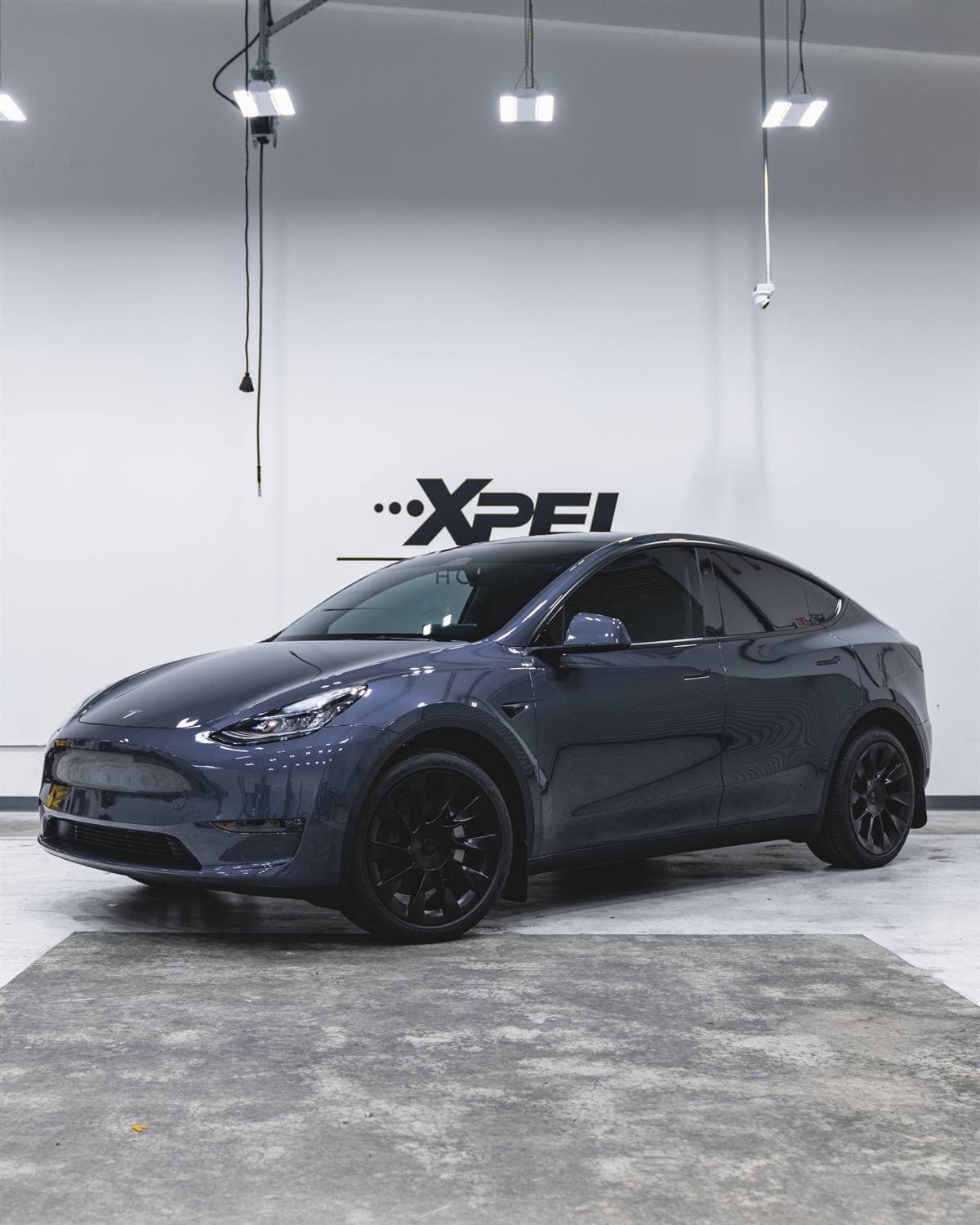 Tinted blue Tesla Model Y inside a Tint World Glenview service bay